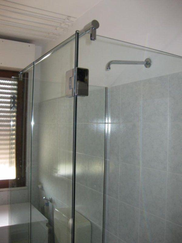 bagno con box doccia in vetro vicino la finestra