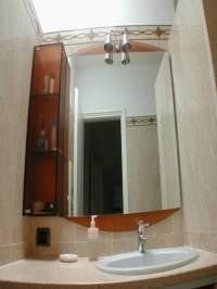 bagno con specchio e mobile in vetro