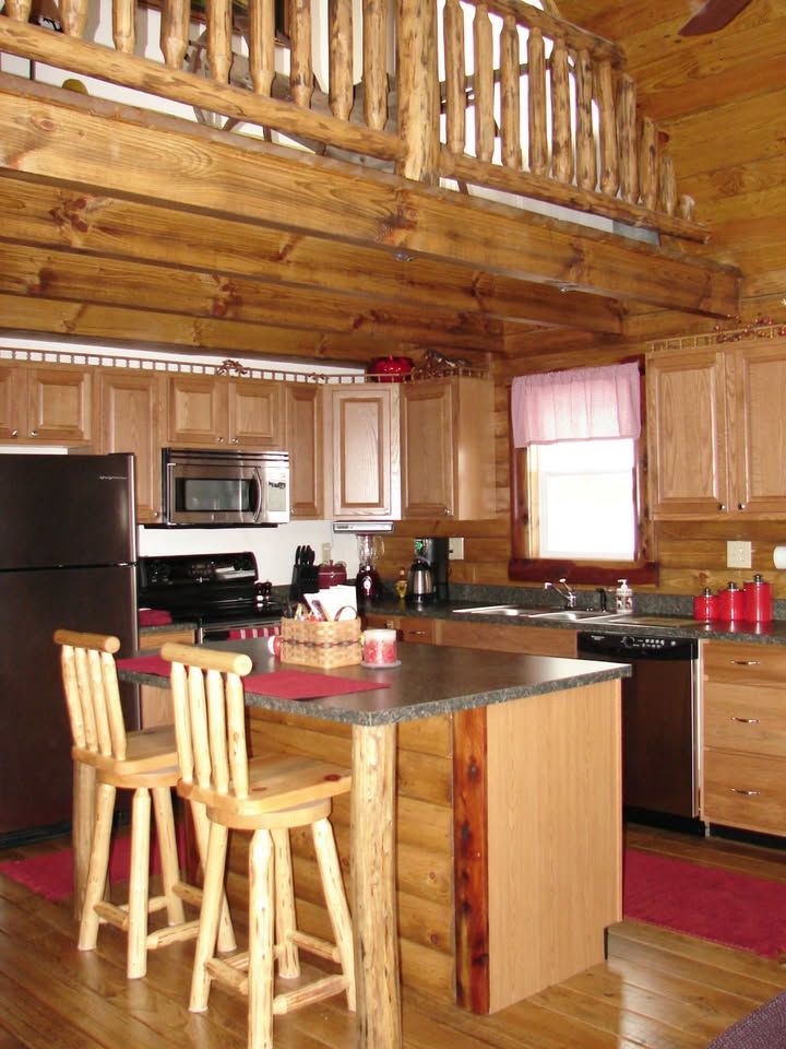 A kitchen in a log cabin with a table and chairs