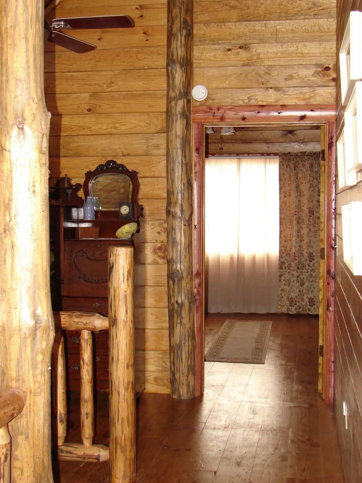 A wooden hallway with a dresser and a ceiling fan