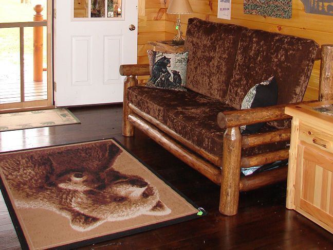 A living room with a couch and a rug with a bear on it