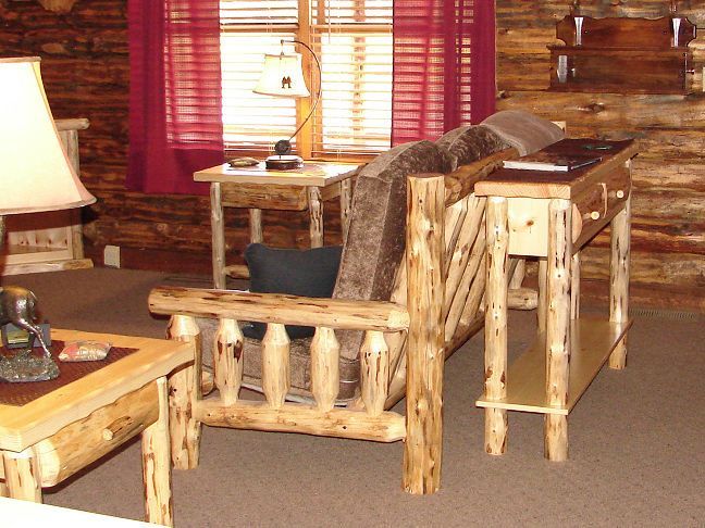 A living room with a couch and chair made of logs