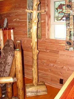 A wooden coat rack is sitting in a room next to a chair.