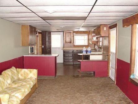 A living room with a couch and a kitchen in the background