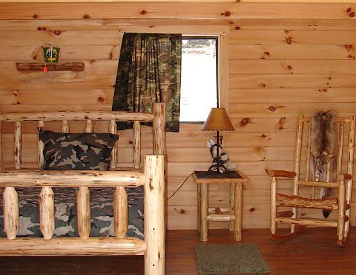A bedroom with a log bed and a rocking chair