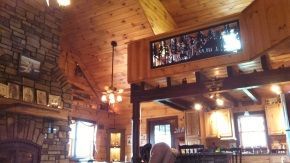 A living room with a brick wall and a wooden ceiling