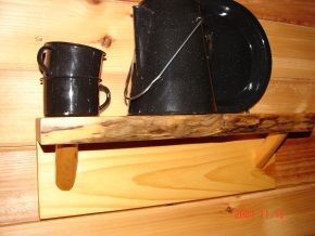A wooden shelf with a bucket and two cups on it