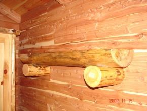 Two logs are hanging on the wall of a log cabin.