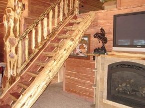 A wooden staircase leading up to the second floor of a log cabin