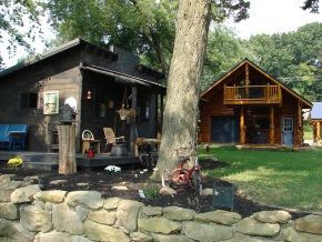 A log cabin with a stone wall in front of it