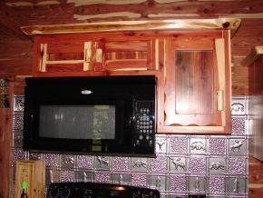 A kitchen with wooden cabinets and a microwave above the stove