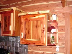 A kitchen in a log cabin with wooden cabinets and shelves