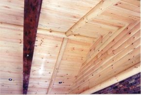 A wooden ceiling with a brick wall in the background