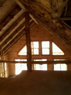 A wooden house with a balcony and a lot of windows