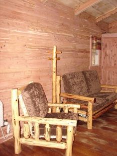 There are two wooden chairs and a couch in the room.