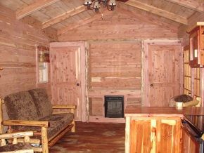A living room with a couch , chairs , and a kitchen.