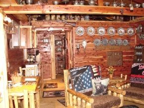 A living room in a log cabin with a table and chairs
