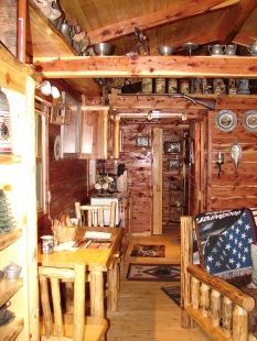 The inside of a log cabin with a table and chairs