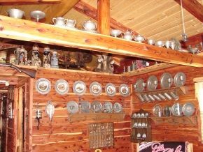 A wooden room with a lot of plates on the wall