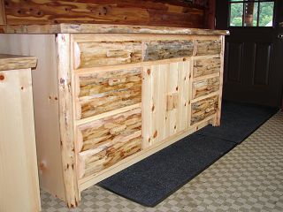 A wooden dresser is sitting in a room next to a window.