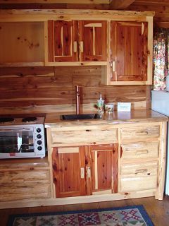 A kitchen with wooden cabinets , a sink , and a microwave.