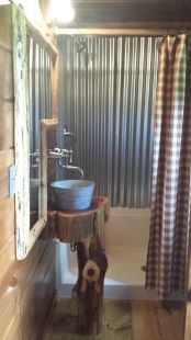 A bathroom with a sink , tub , mirror and shower curtain.