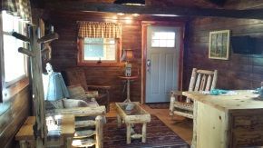 A living room with a table , chairs , and a door.