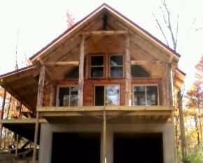 A large wooden house with a garage underneath it