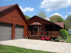 A log cabin with a porch and a garage