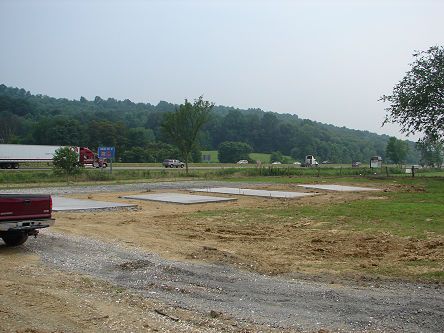 A red truck is parked in the middle of a dirt road.