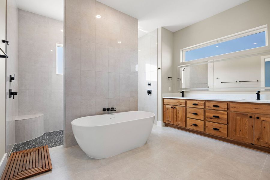 A bathroom with a bathtub and two sinks.