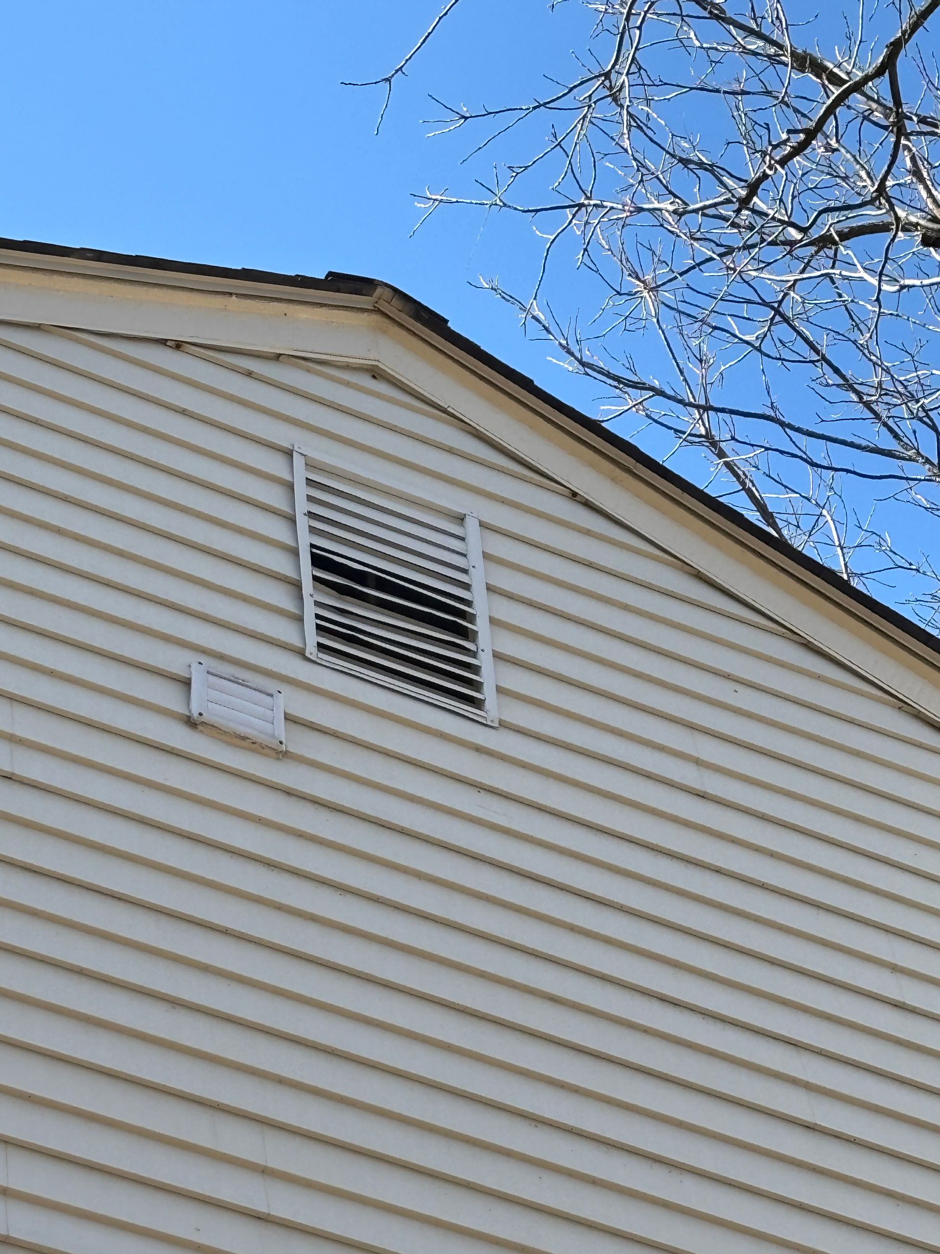 A white house with a roof vent on the side