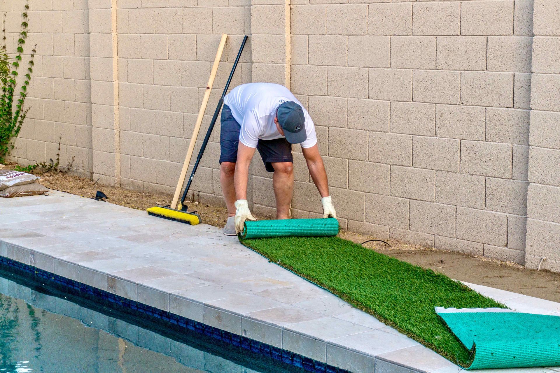 Affordable Landscaper Rolling Out Artificial Turf Near Pool