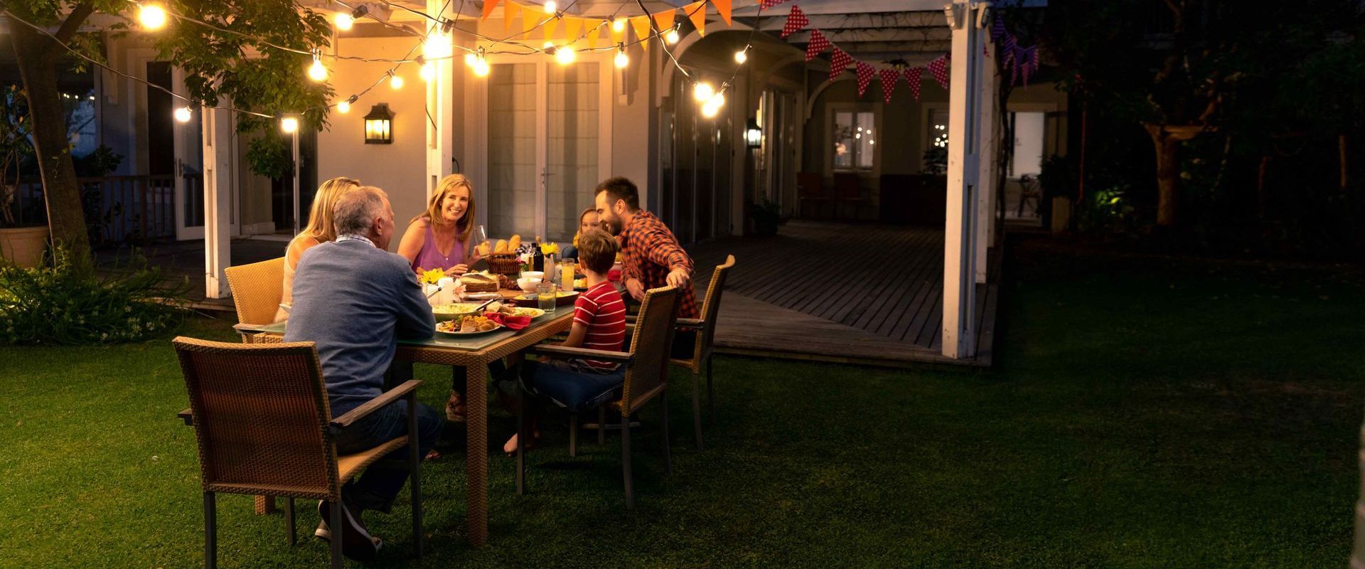 Caucasian Family Eating Together At Backyard Dinner Table