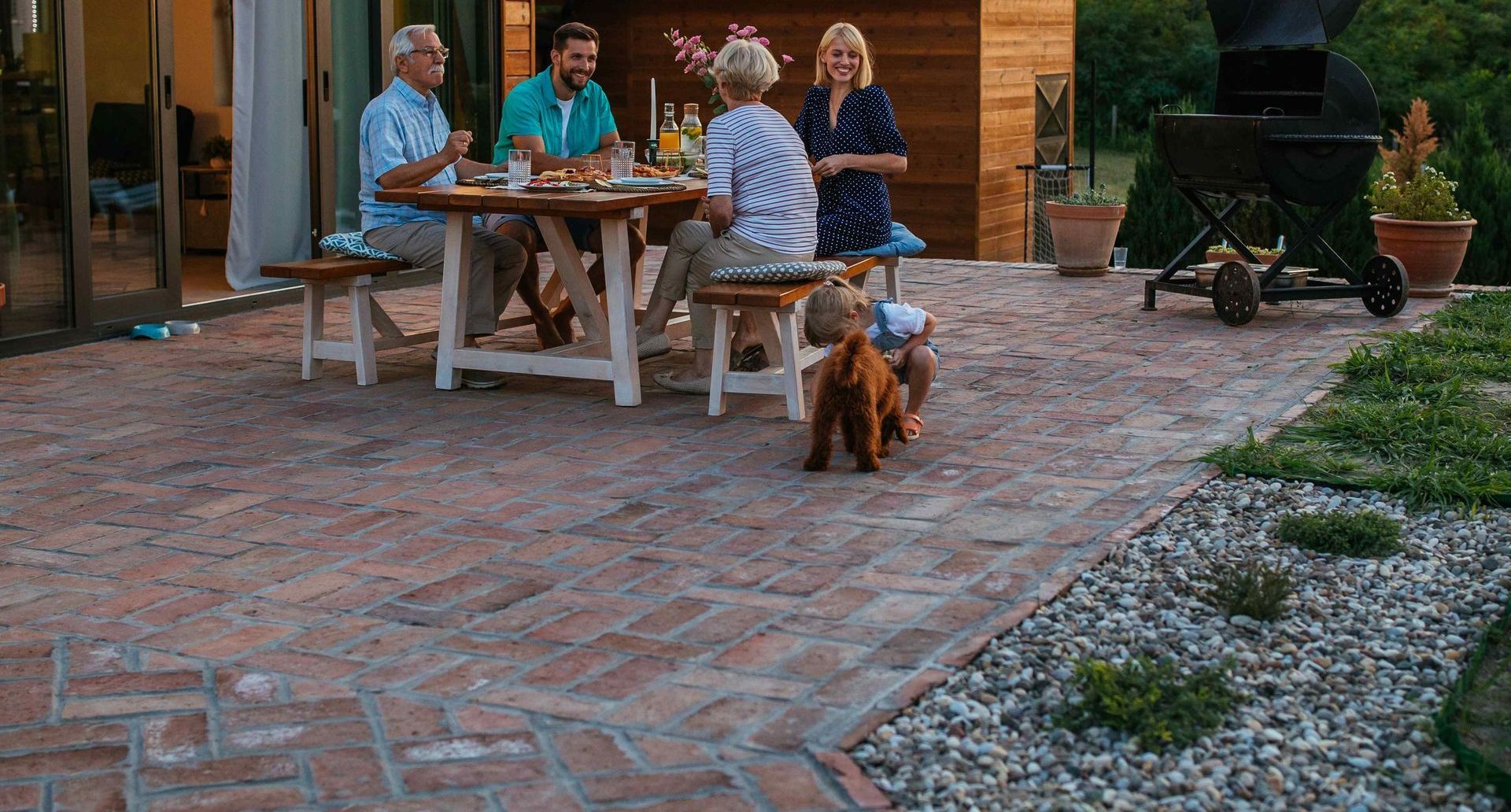 Cheerful Family Enjoying Dinner Outside On Back Patio During Evening