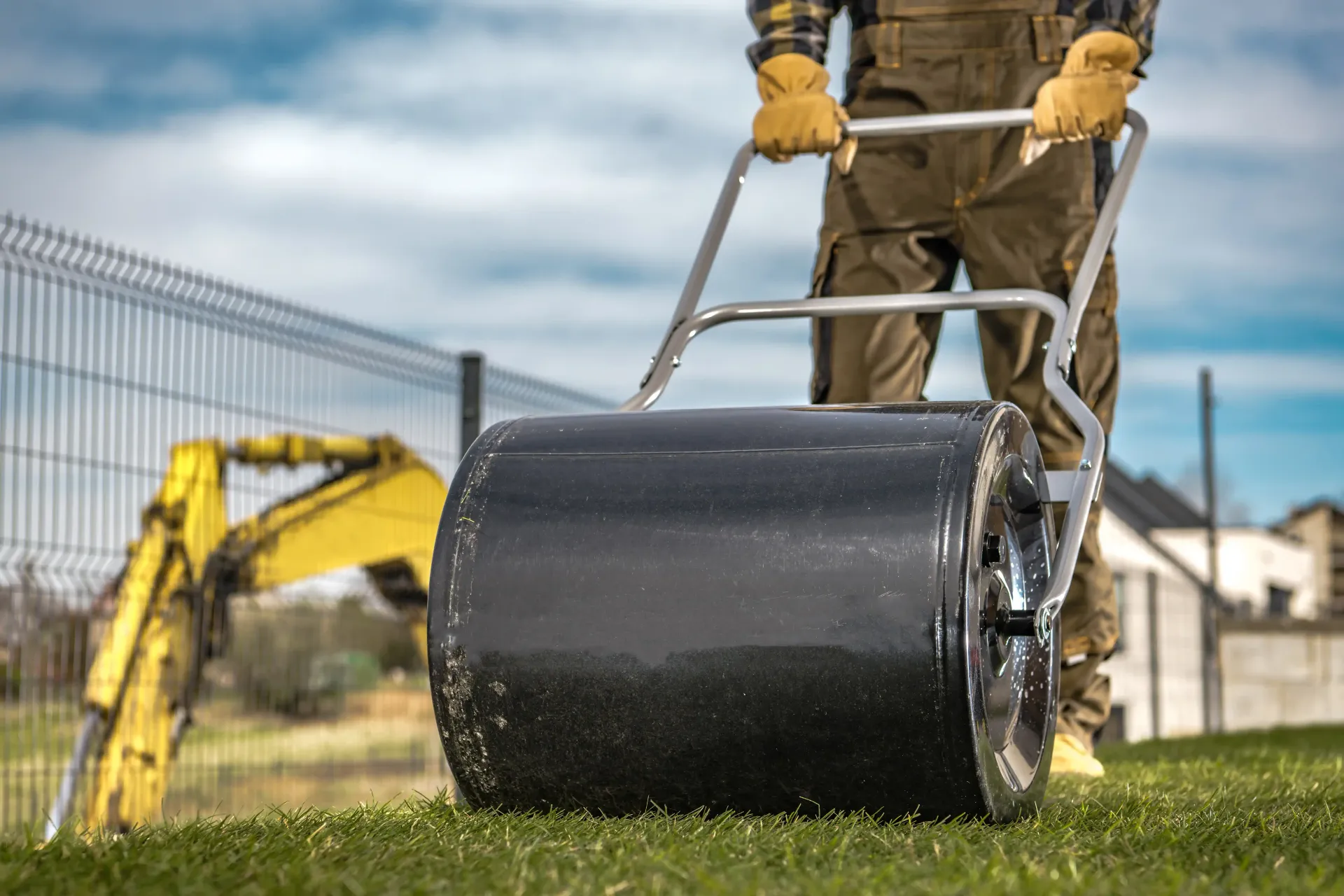 Landscaper Smoothing Artificial Turf With Roller