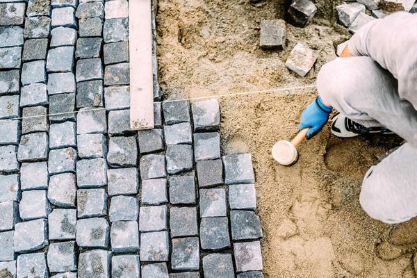 Professional Landscaper Installing Granite Paver Stone Patio