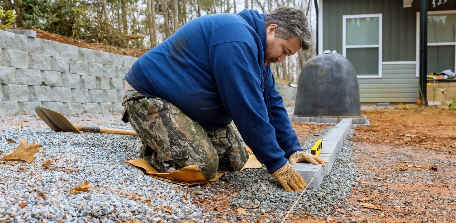 Professional Landscaper Installing Hardscape In Winter