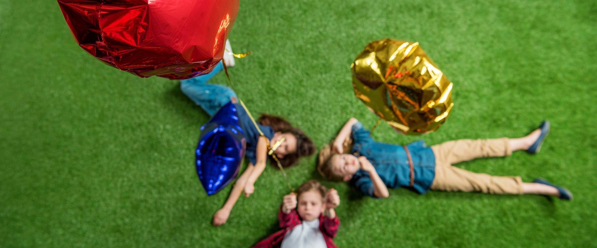 Top View Kids Laying On Fake Grass After Playing