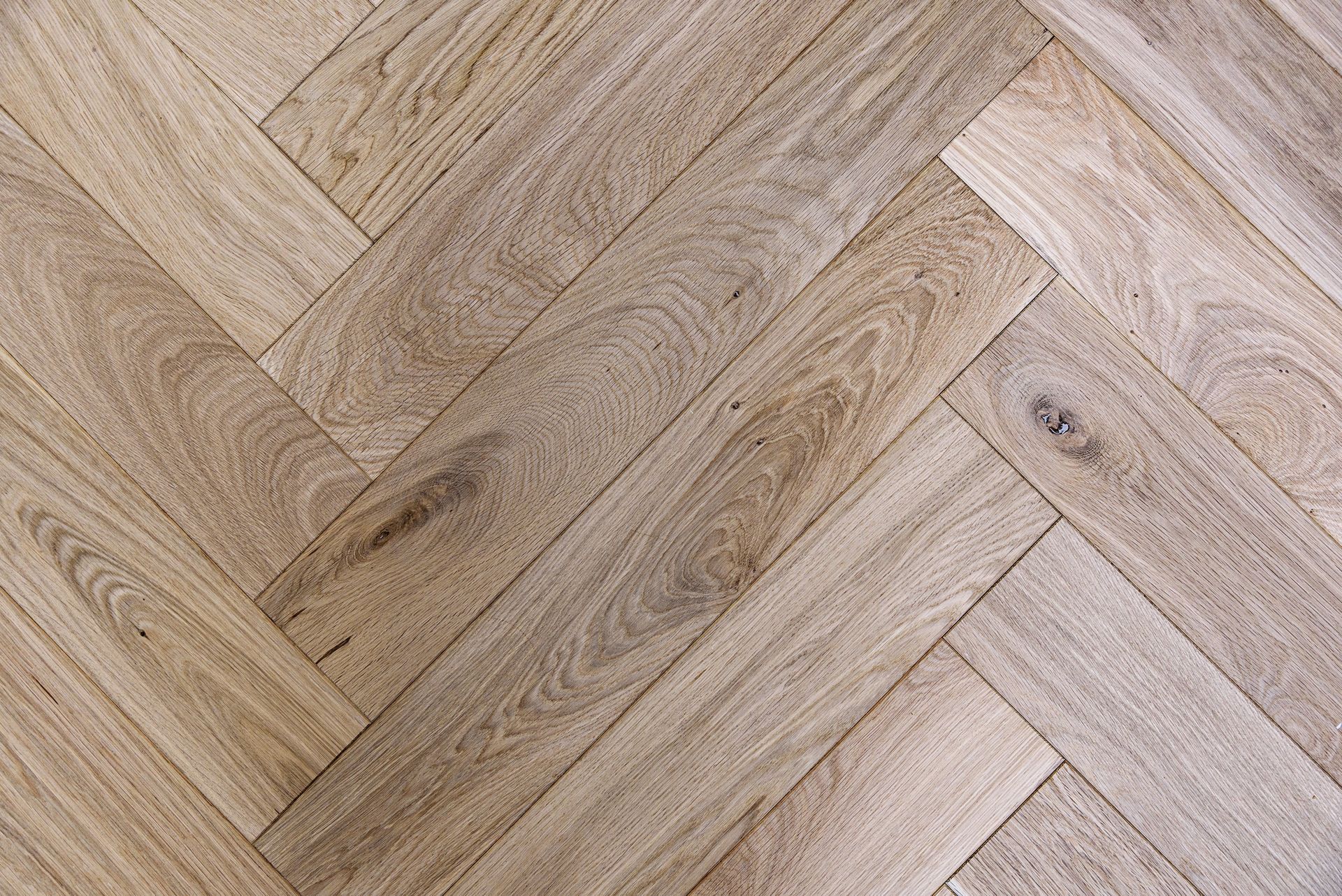 A close up of a wooden floor with a herringbone pattern.