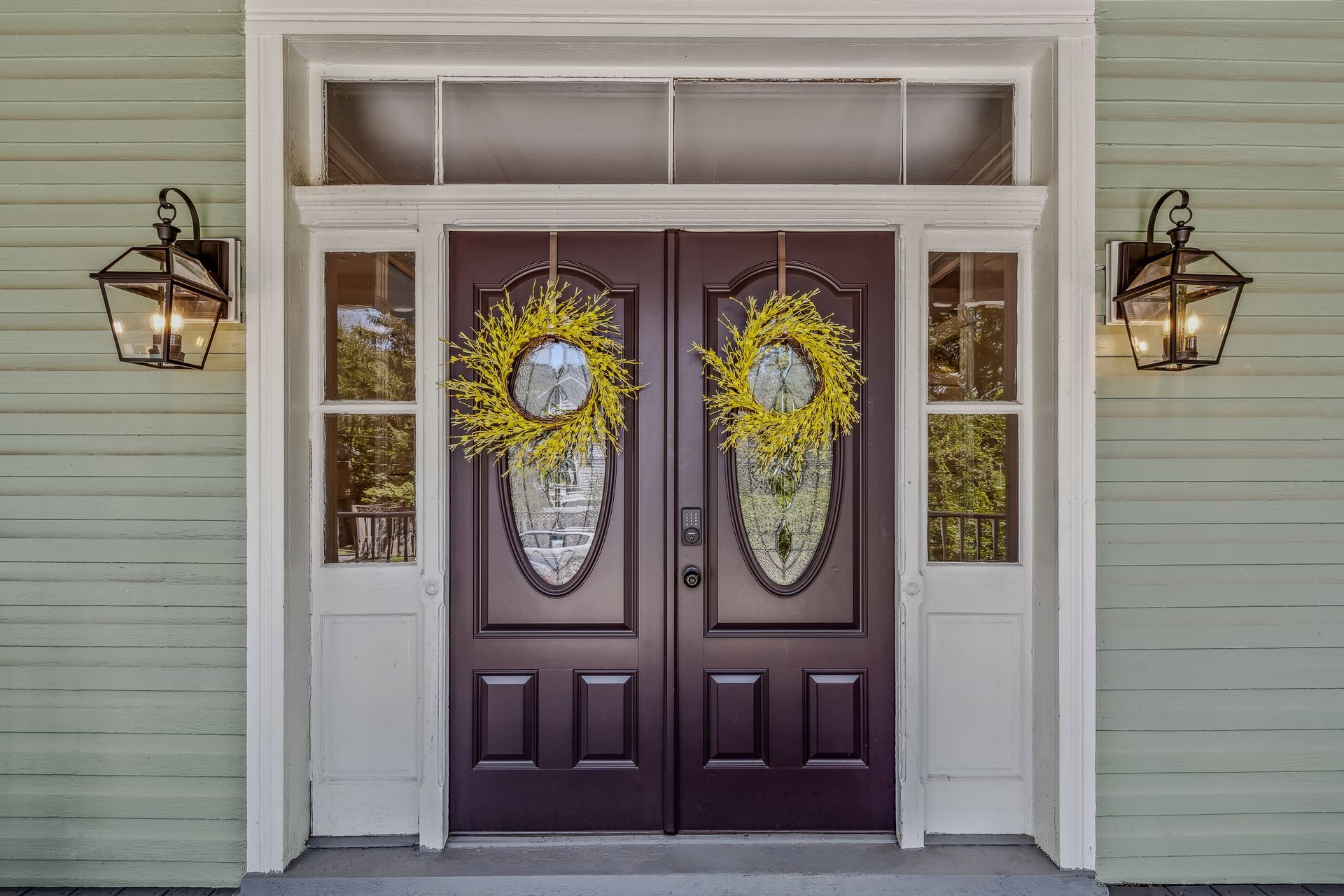 The front door of a house with a sunflower wreath on it.
