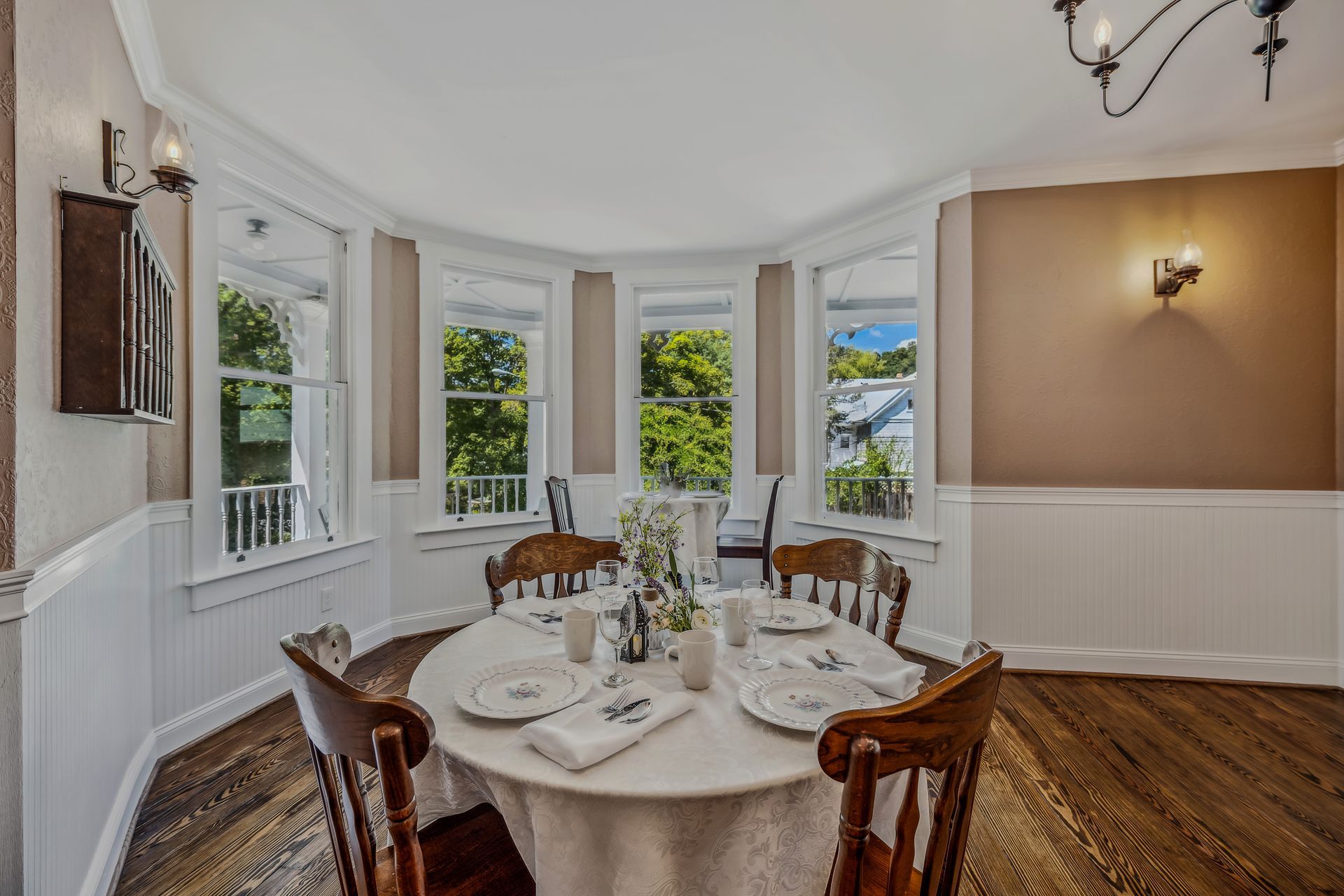 A dining room with a round table and chairs and a chandelier.