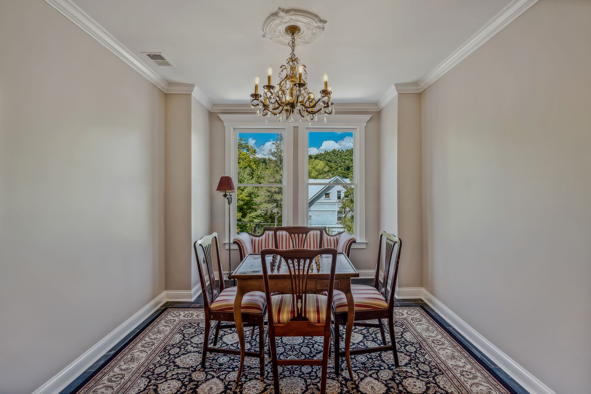 A dining room with a table and chairs and a chandelier.