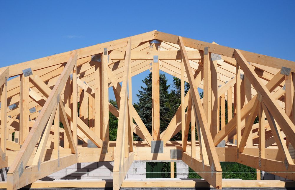 Wooden Roof Trusses Under Construction Against a Blue Sky — Brayden Stewart Building In Forster, NSW