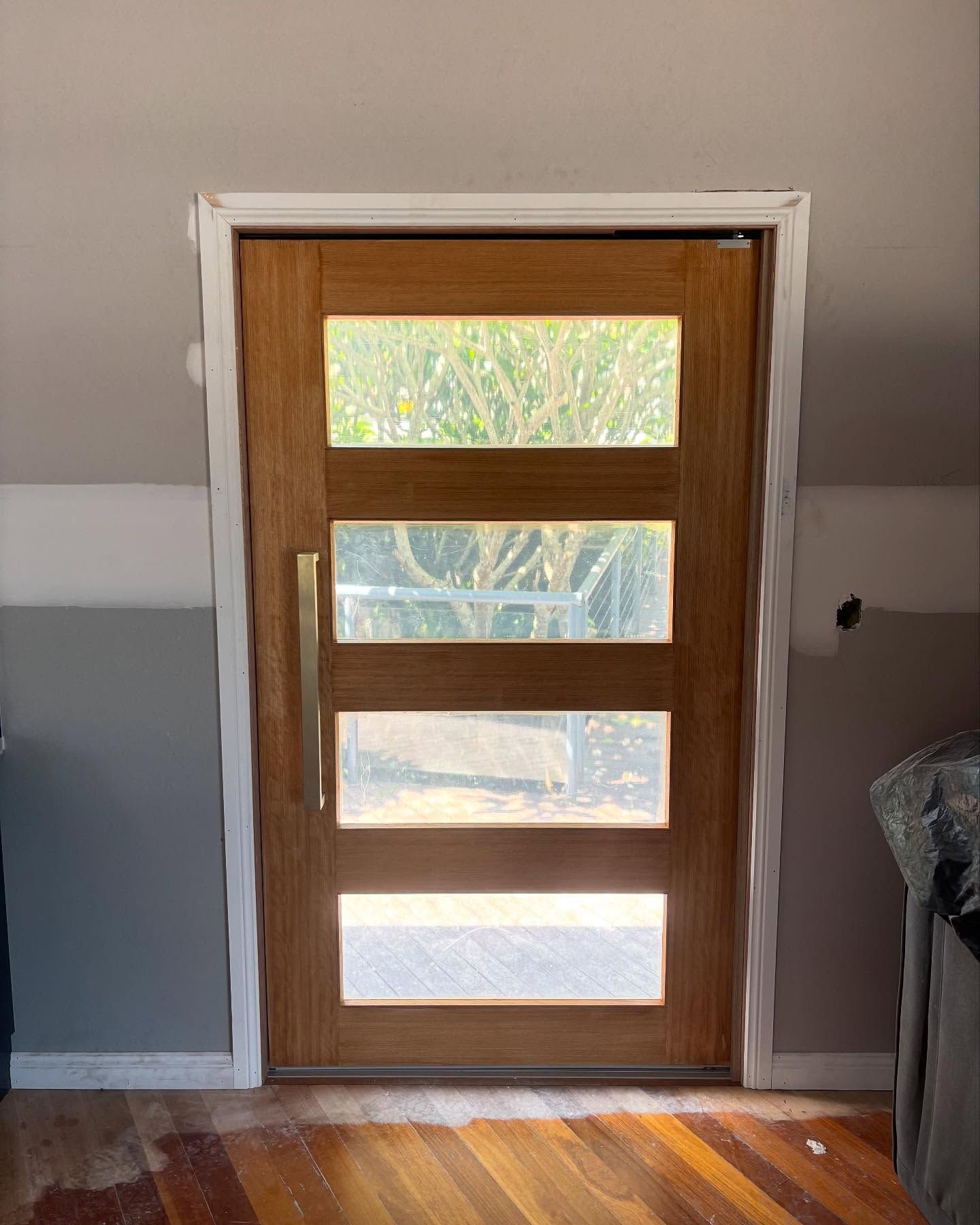 Wooden Door With Four Glass Panels and Gold Handle — Brayden Stewart Building In Tuncurry, NSW