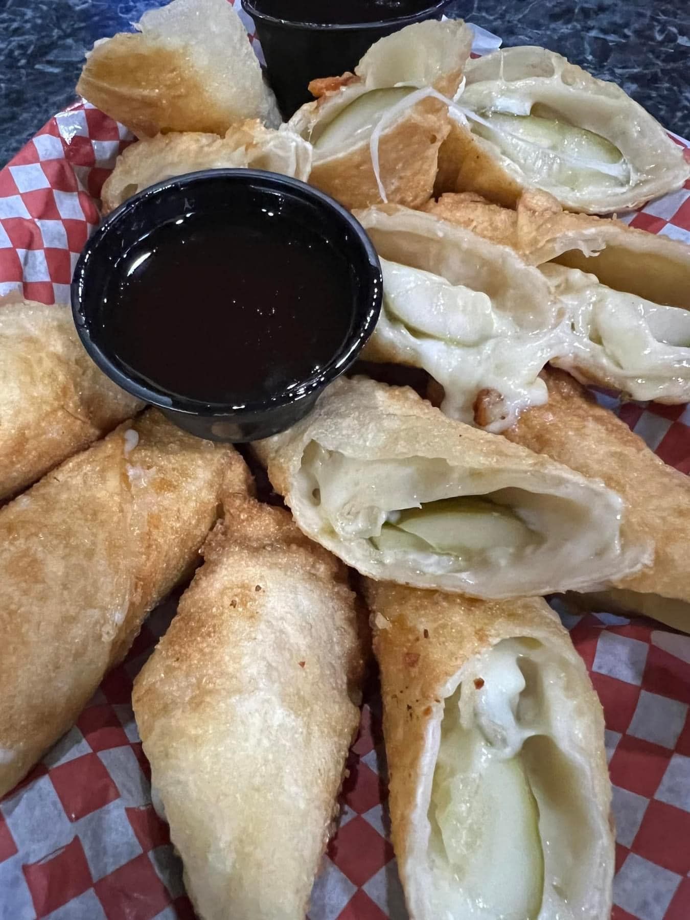 A close up of a plate of food with a bowl of dipping sauce.
