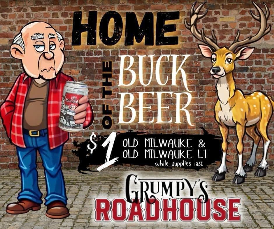A man in a plaid shirt is holding a can of beer next to a deer.