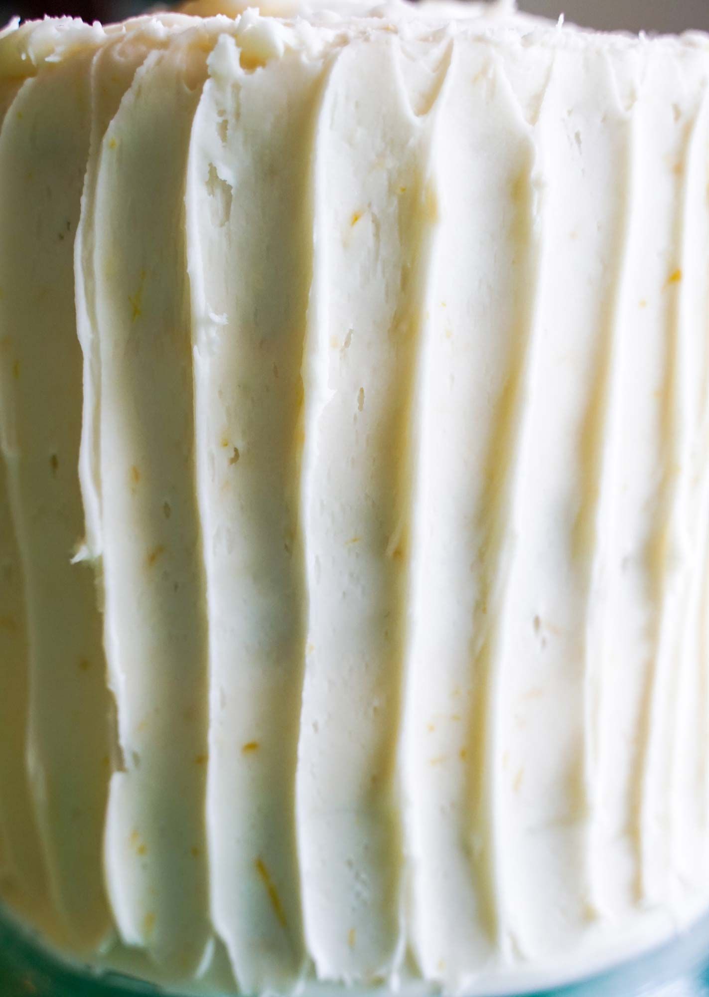 A close up of a cake with white frosting on a table.