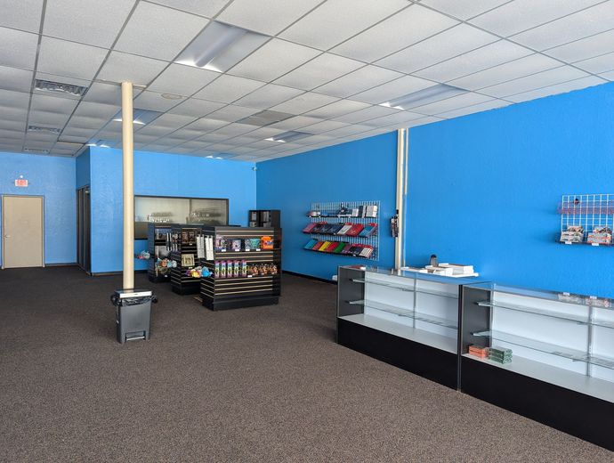 An empty store with blue walls and shelves