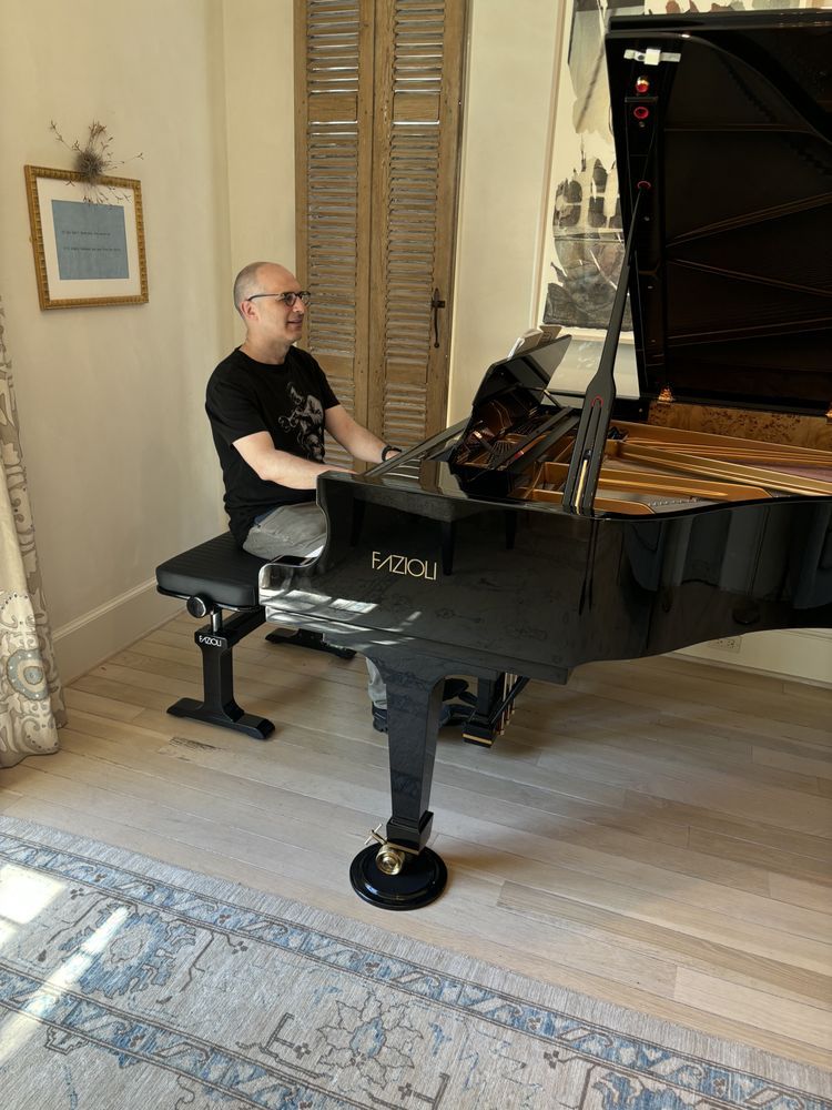 A man is carrying a white piano in a living room.